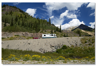 RV climbing a hill with car in tow