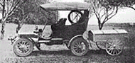 1900s car pulling a popup tent in a trailer